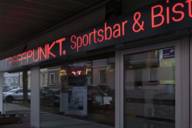 Red neon lettering on the Treffpunkt sports bar in Munich