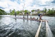 Raft builders assemble a raft on the river.