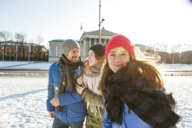 A couple and a woman are wearing winter clothes at Königsplatz in Munich.