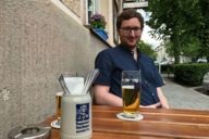 Man with beer in front of a restaurant in Munich.