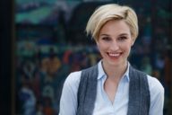 A young woman with short blond hair is standing in front of a painting at Lenbachhaus in Munich.