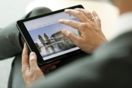 Close-up of a tablet in the hands of a woman.