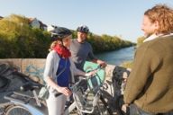 A group of cyclists is talking to each other on a bridge at the Isar River in Munich.