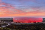 The Allianz Arena in Munich illuminated in red at sunset.