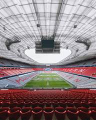 View of the interior of the Allianz Arena with the FC Bayern logo in the background.