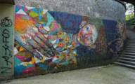 Colourful human figure painted on a wall in the style of street art