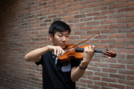 The musician Yusi Chen plays his violin in Munich.