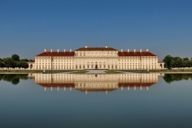 The silhouette of Schleissheim Palace is reflected in the water of the canal. 