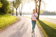 A woman is jogging through the Olympic Park in Munich in the evening sun.