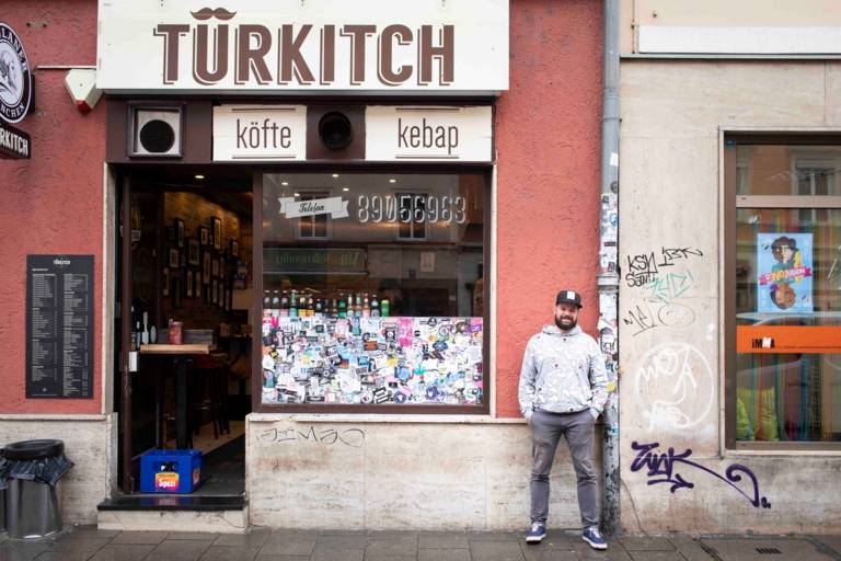 Chef Florian Berger of Restaurant Gabelspiel in Munich with a cap stands in front of Turkish snack bar Türkitsch in Munich.
