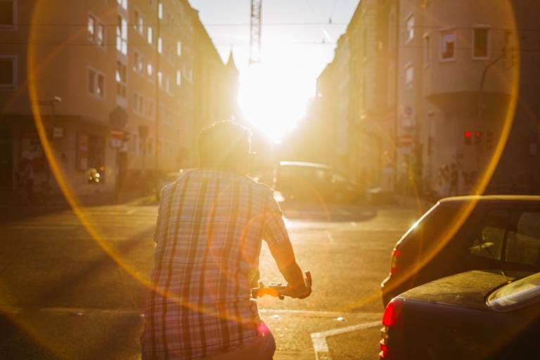 A man on a bicycle in the evening sun in the Maxvorstadt in Munich