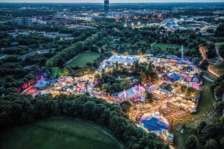 The Munich Summer Tollwood Festival in the Olympiapark photographed from above with a drone at nightfall.