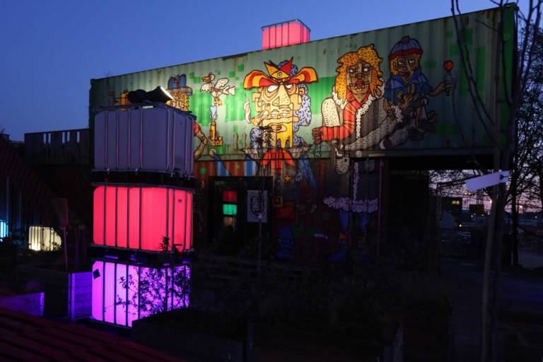 Illuminated containers in the Werksviertel Mitte at night.