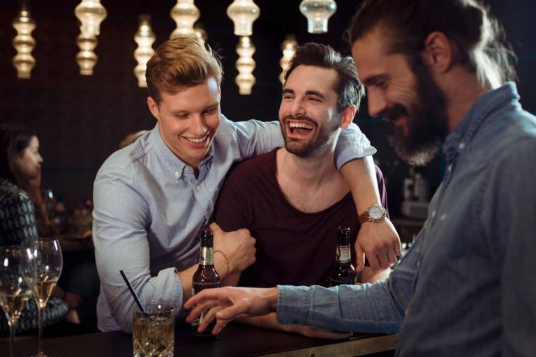 Three men are having fun in a bar in Munich.