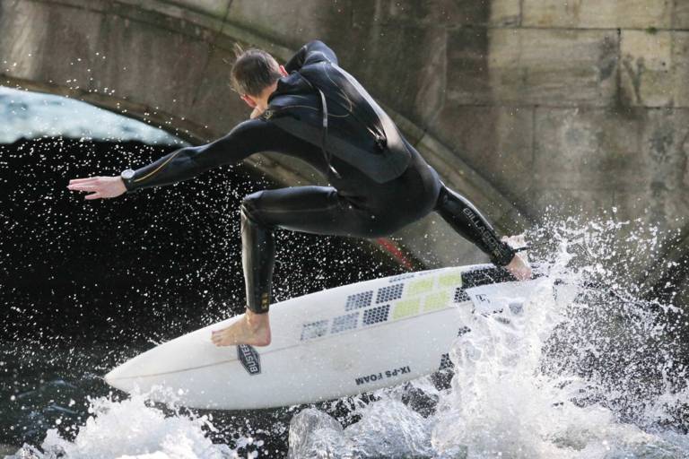 At the Eisbach bridge there are spectators day and night watching the surfers riding the waves.