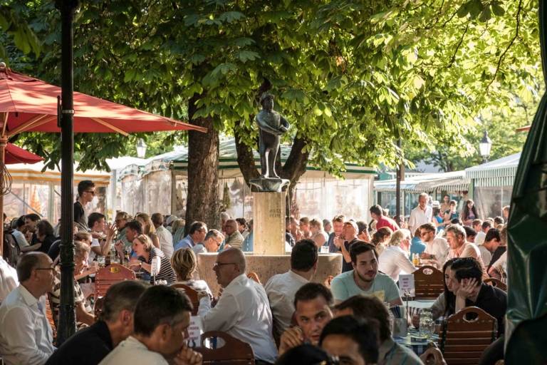 People in a beer garden at the Viktualienmarkt in Munich.