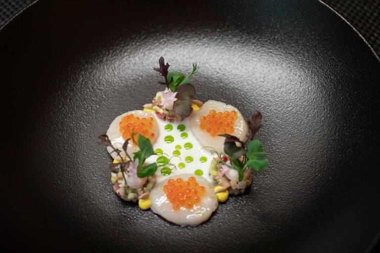 A dish with caviar on a black plate at the Atelier restaurant in Munich