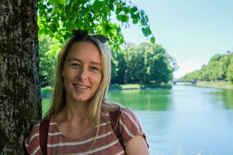 Sarah Althaus stands by a tree on the Nymphenburg Palace canal.