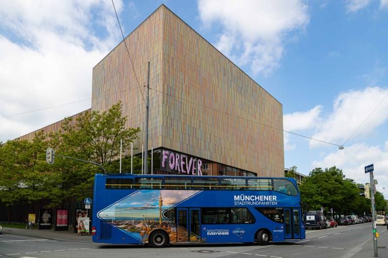 Un autobús turístico azul frente al Museo Brandhorst.