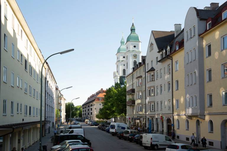 A street in Giesing with residential buildings and a church