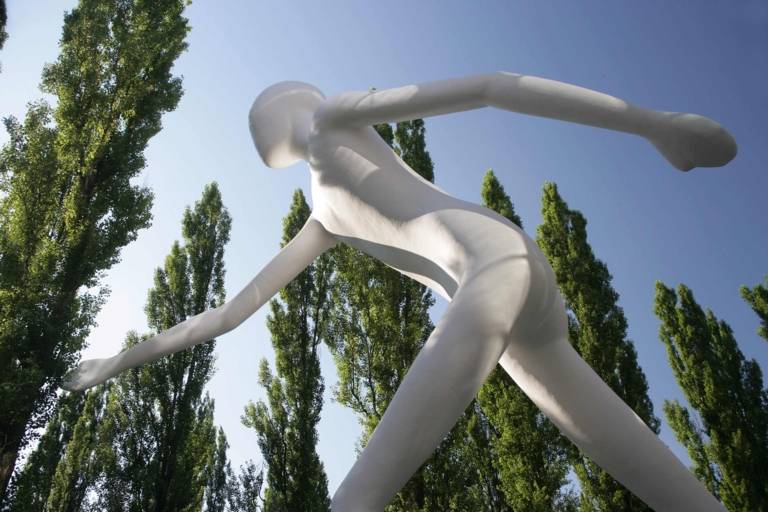 The sculpture "Walking Man" made by Jonathan Borofsky in front of the Munich Re at Leopoldstraße in Munich.