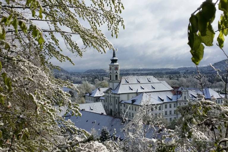 View from above of a snow-covered winter landscape with a monastery in the outskirts of Munich.