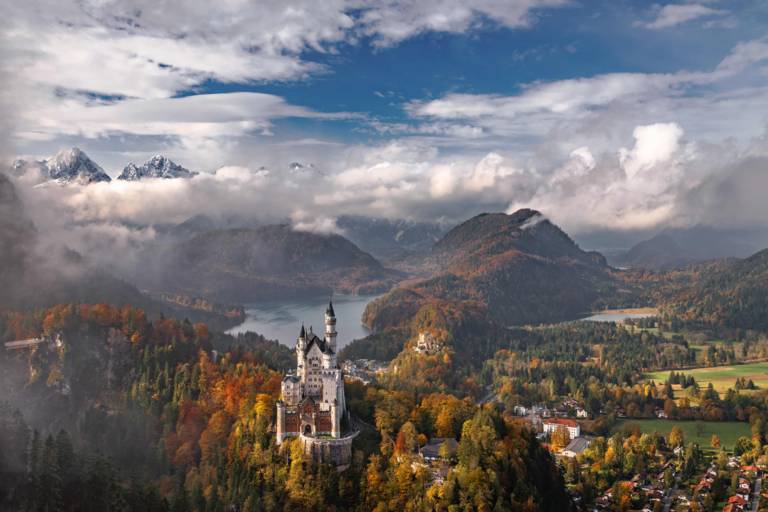Neuschwanstein Castle framed by autumnal forests and mountains