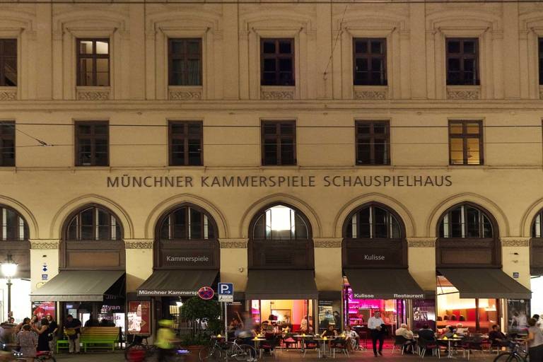 Front view of the Münchner Kammerspiele at Maximilianstraße in Munich at night.
