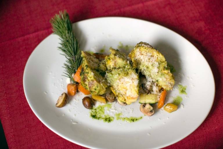 A vegetarian dish called Latschenkiefer-Topfenknödel is served on a plate.