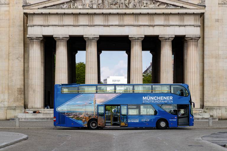 Un autobús azul de dos pisos para turistas frente a la Königsplatz.
