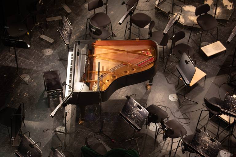 View into an orchestra pit with a large piano in Munich.