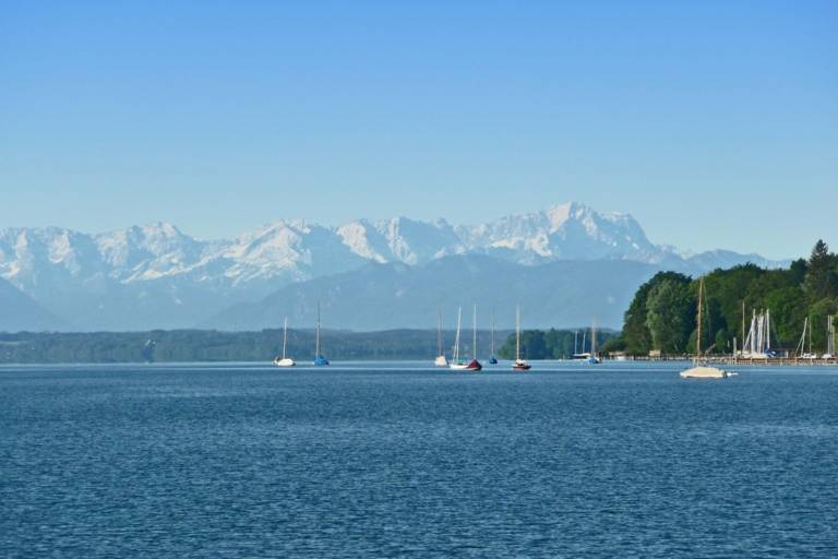 Boats in Starnberger See in the Five Lake Region nearby Munich with the Alps in the background.