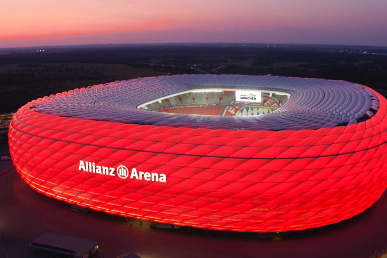 The Allianz Arena in Munich illuminated in red at night.