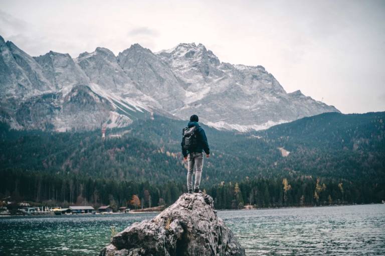 Homme debout sur un rocher au bord du lac Eibsee, près de Garmisch, dans la banlieue de Munich.