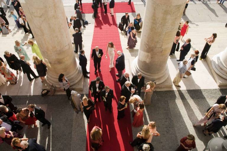 People on a red carpet at the entrance of the Bavarian State Opera during the Opera Festivals in Munich.
