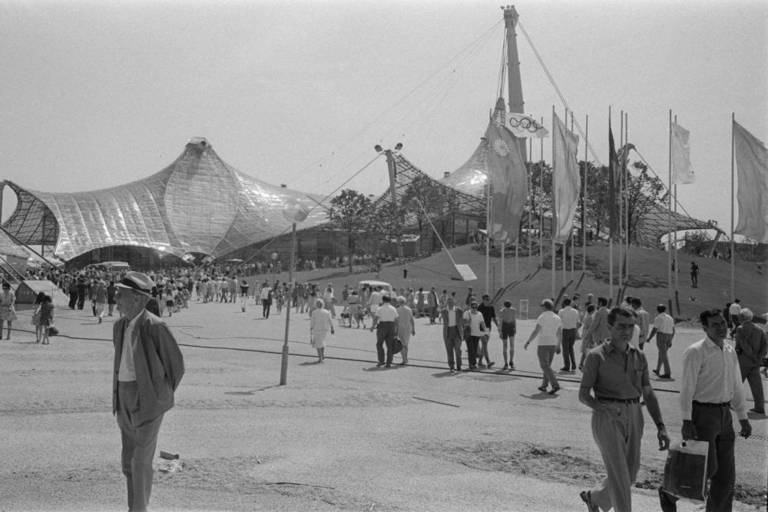 Several people are walking on the 1972 Olympic site in Munich